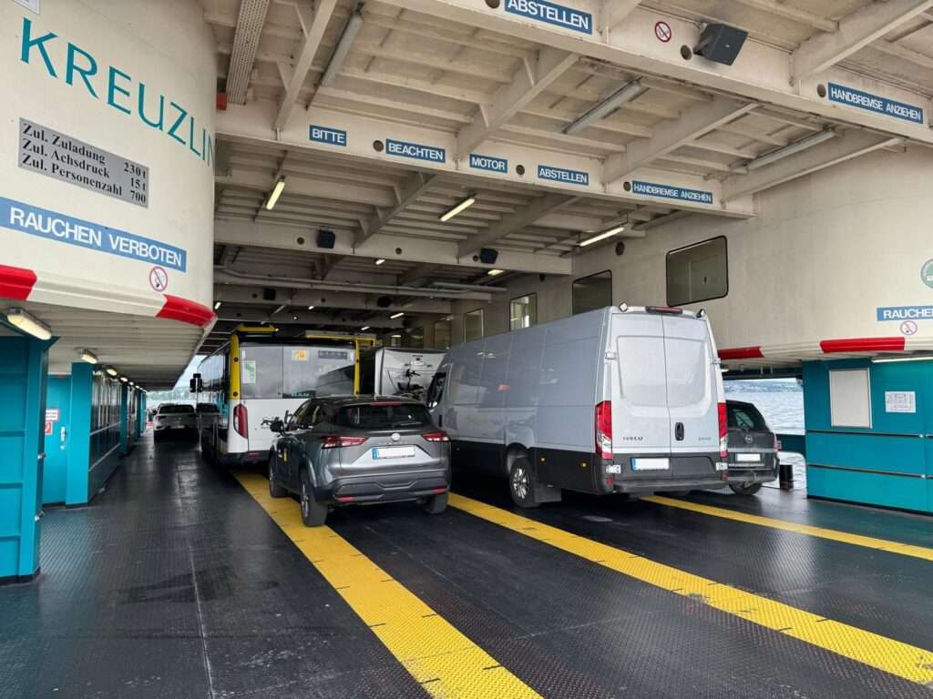 Grauer IVECO Sprinter von Trans KLAS auf einer Fähre während eines Transportauftrags.