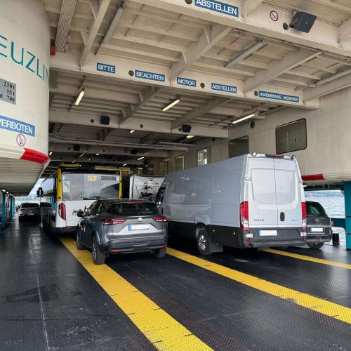 Grauer IVECO Sprinter von Trans KLAS auf einer Fähre während eines Transportauftrags.